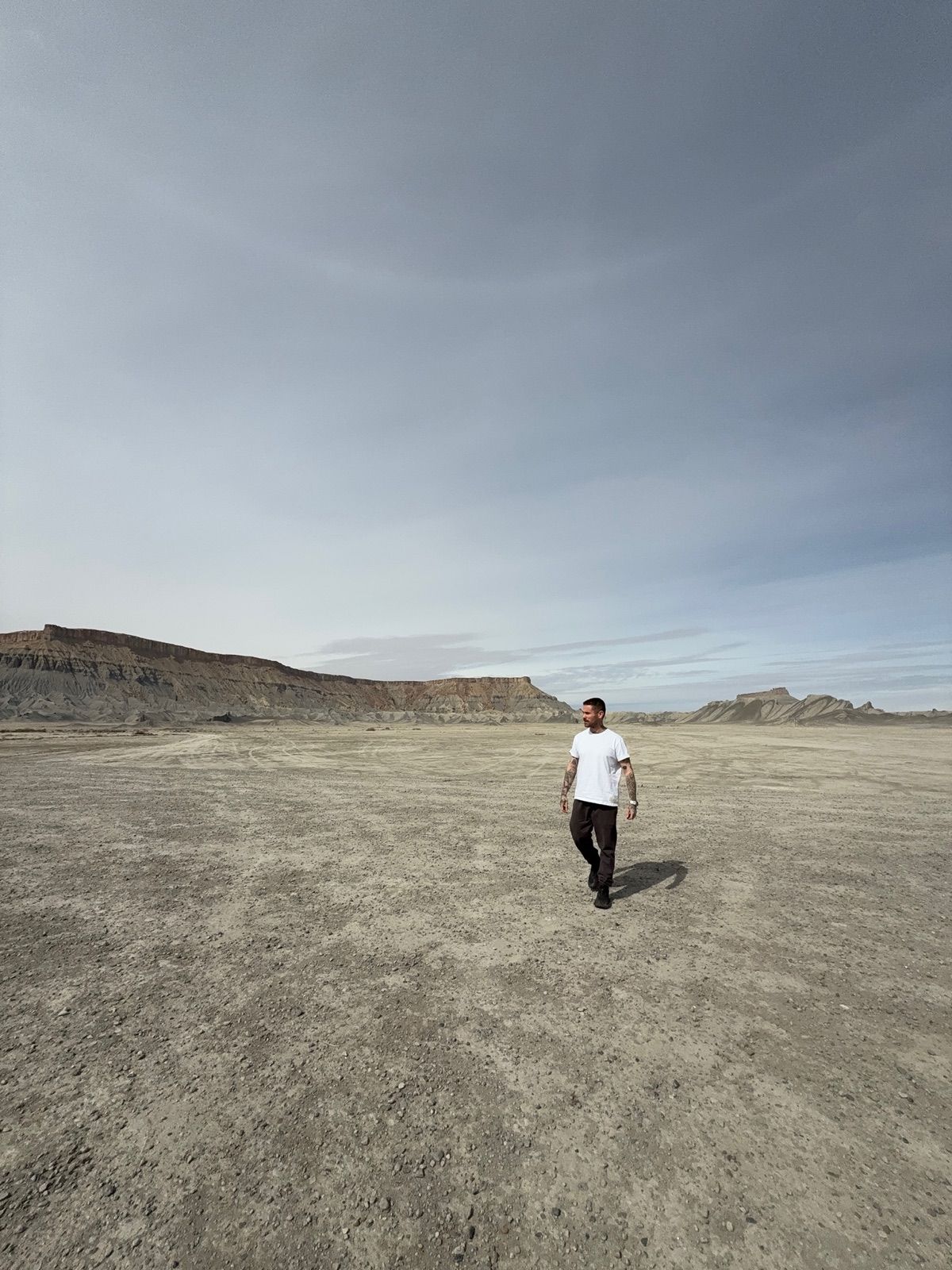 Victor walking across a desert badlands landscape